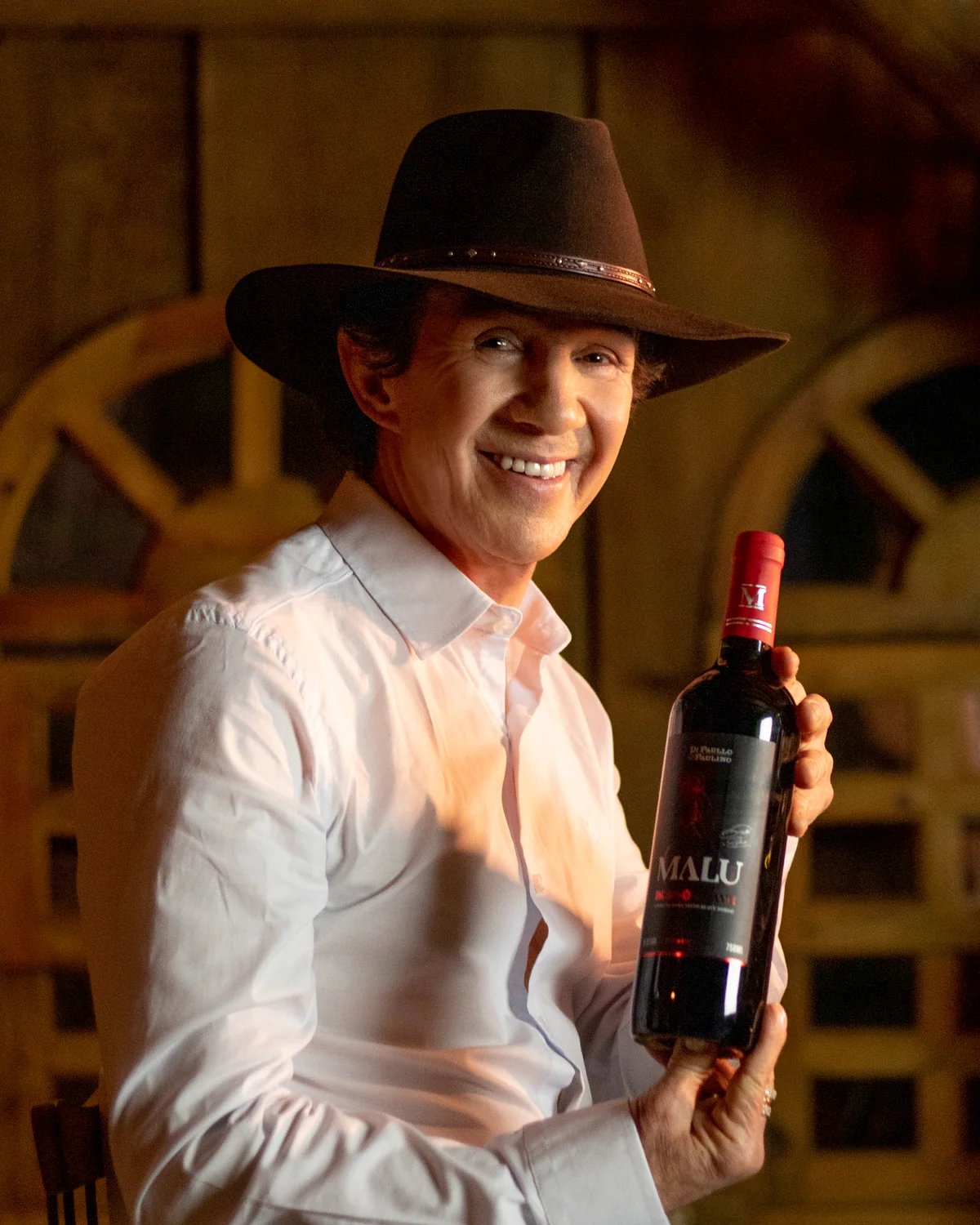 Di Paullo com uma garrafa de vinho Malu